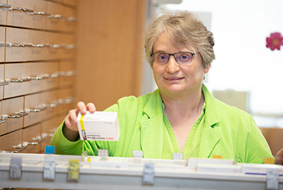 Apothekerin am Medizinschrank